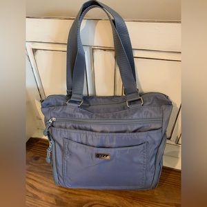 Handbag never used.
place to slip on the handle of a suitcase.